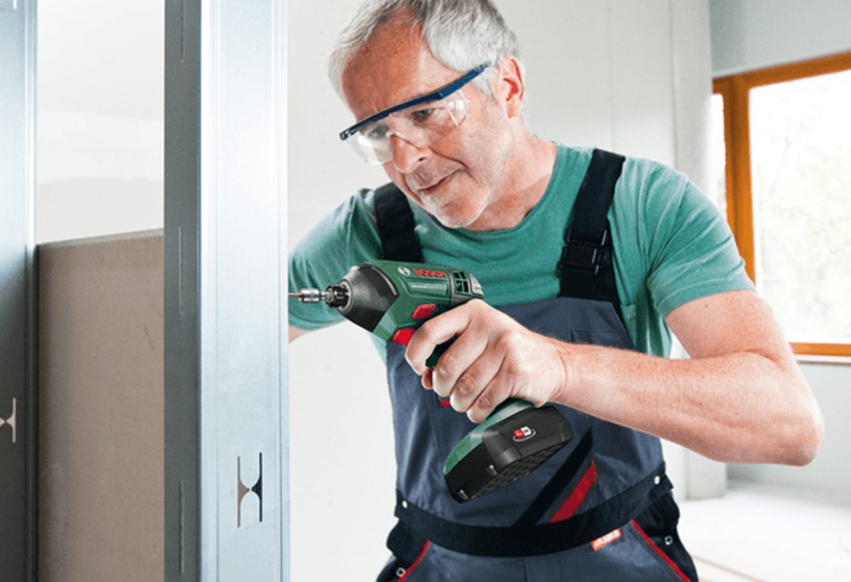 Απεικονίζεται άνδρας να χρησιμοποιεί το εργαλέιο για διάτρηση σε μέταλλο.